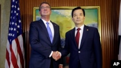 U.S. Defense Secretary Ash Carter, left, shakes hands with South Korea's Defense Minister Han Min Koo during their bilateral meeting on the sidelines of the 15th International Institute for Strategic Studies Shangri-la Dialogue, or IISS, Asia Security Summit in Singapore, June 4, 2016. 