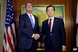U.S. Defense Secretary Ash Carter, left, shakes hands with South Korea's Defense Minister Han Min Koo during their bilateral meeting on the sidelines of the 15th International Institute for Strategic Studies Shangri-la Dialogue, or IISS, Asia Security Sum