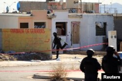 Policemen are seen at a crime scene following an attack on municipal police officers by drug hitmen, according to local media, in Ciudad Juarez, Mexico, Dec. 13, 2018.