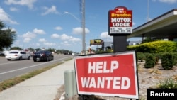 FILE - A Brandon Motor Lodge displays a "Help Wanted" sign in Brandon, Florida.