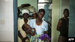 In this file photo, an HIV positive mother holds her sick child at the Thyolo District hospital in Malawi, Nov. 26, 2014.