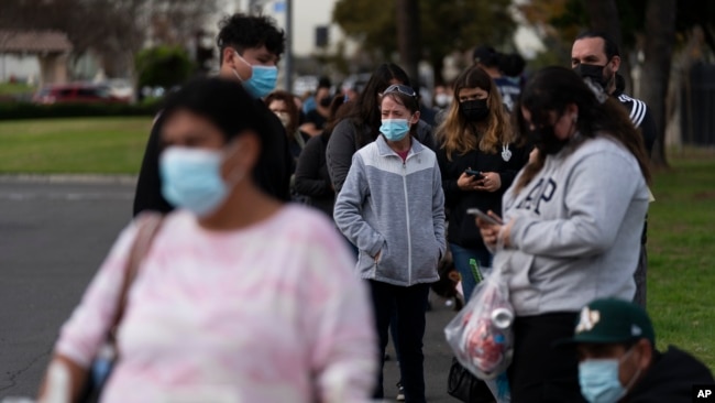 FILE - People wait in line for a COVID-19 test at a mobile testing site in Paramount, California, Jan. 12, 2022. (AP Photo/Jae C. Hong)