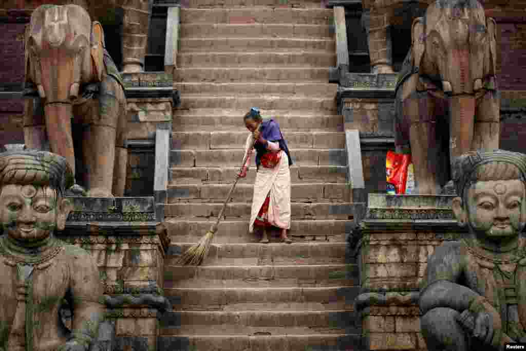 A woman sweeps the premises of Nyatapola Temple in Bhaktapur, Nepal.