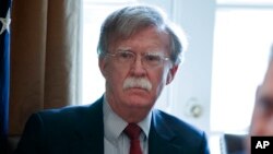 FILE - National Security Adviser John Bolton listens as President Donald Trump speaks during a Cabinet meeting at the White House in Washington, April 9, 2018.