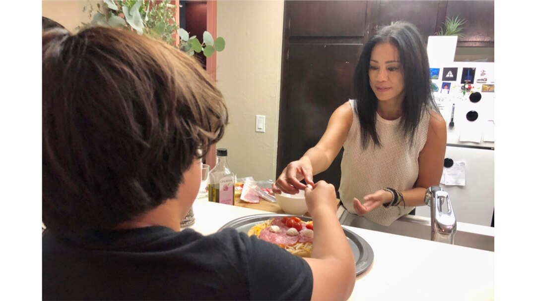 Keryn Francisco membuat pizza bersama putranya Reve Francisco (10 tahun) di Alameda, California, Selasa, 2 November 2021. (AP Photo/Haven Daley)