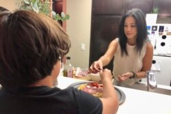 Keryn Francisco membuat pizza bersama putranya Reve Francisco (10 tahun) di Alameda, California, Selasa, 2 November 2021. (AP Photo/Haven Daley)