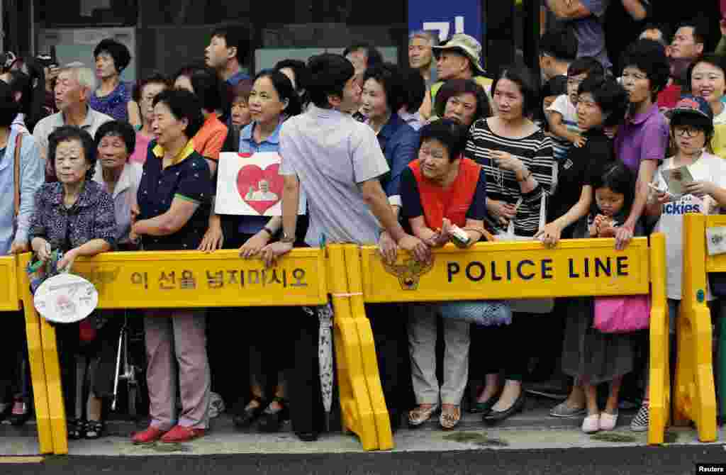 People wait for Pope Francis to arrive for a meeting with bishops, in front of the headquarters of the Korean Episcopal Conference in Seoul, Aug. 14, 2014.