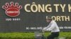 FILE - A man rides a bicycle past a Kinh Do factory in Vietnam's northern Hung Yen province, outside Hanoi.