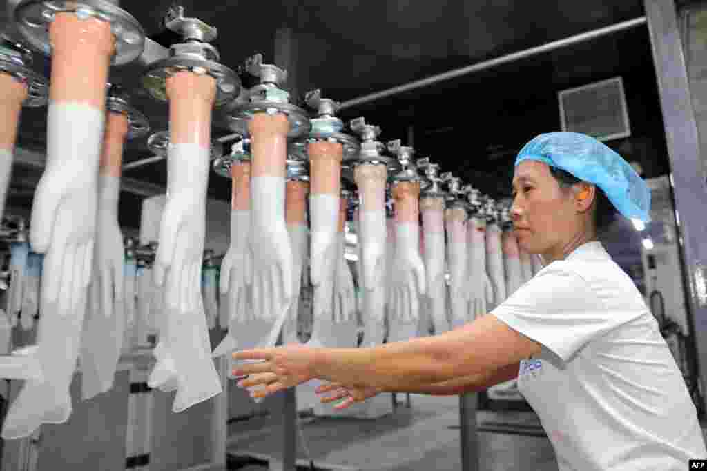 An employee works on a medical glove production line at a factory in Huaibei in China&#39;s eastern Anhui province, Aug. 14, 2019.