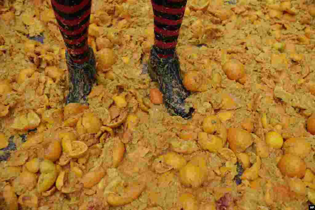 A man stands on a carpet of smashed oranges during Carnival in the northern Italian Piedmont town of Ivrea, Italy.