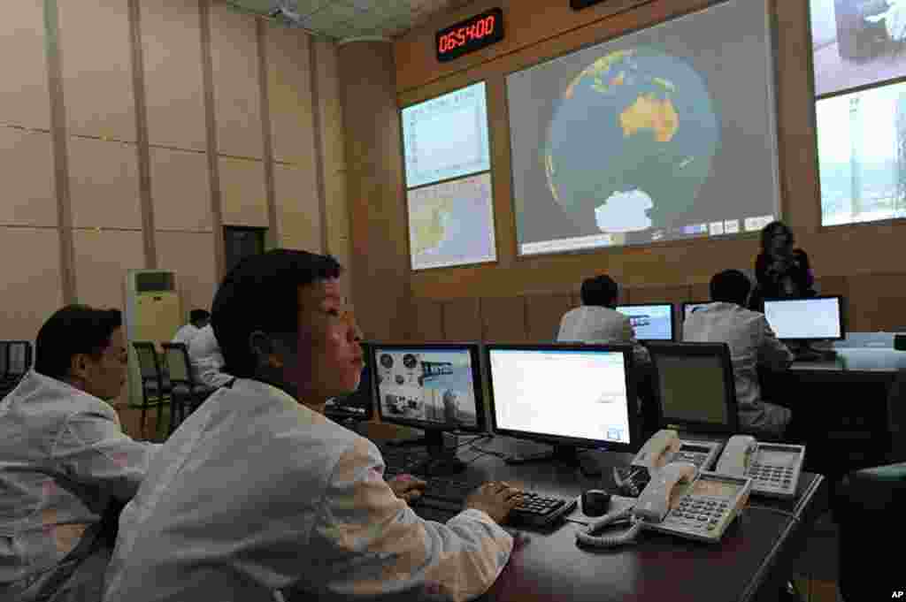 North Korean technicians work at the control room of the Tongchang-ri space center on April 8, 2012. (AFP photo)