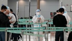 A quarantine officer wearing protective gears waits to guide travelers at the departure hall of the Incheon International Airport in Incheon, South Korea, Dec, 7, 2021.