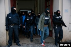 German special police units leave an apartment building in Berlin's Wedding district where suspected jihadists were targeted in a raid, Jan. 16, 2015.