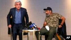 Former Armenian President Serzh Sargsyan (L) walks out of a meeting with protest leader Nikol Pashinian (R) in Yerevan, Armenia, April 22, 2018. 