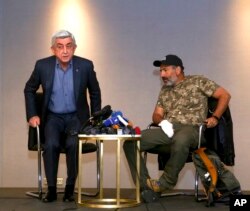 Former Armenian prime minister Serzh Sargsyan (L) walks out of a meeting with protest leader Nikol Pashinian (R) in Yerevan, Armenia, April 22, 2018.