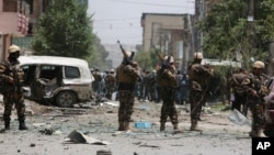 Afghan security personnel inspect the site of a suicide attack that targeted a NATO convoy in Kabul, Afghanistan, July 7, 2015. 