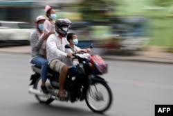 រូបឯកសារ៖ ពលរដ្ឋកម្ពុជាមួយគ្រួសារកំពុងធ្វើដំណើរតាមម៉ូតូ ដោយមានពាក់ម៉ាស់ នៅទីក្រុងភ្នំពេញ ថ្ងៃទី ២៨ ខែមេសា ឆ្នាំ២០២០។
