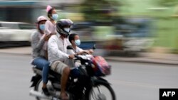 រូបឯកសារ៖ ពលរដ្ឋកម្ពុជាមួយគ្រួសារកំពុងធ្វើដំណើរតាមម៉ូតូ ដោយមានពាក់ម៉ាស់ដើម្បីការពារការឆ្លងជំងឺកូវីដ១៩ នៅទីក្រុងភ្នំពេញ ថ្ងៃទី ២៨ ខែមេសា ឆ្នាំ២០២០។