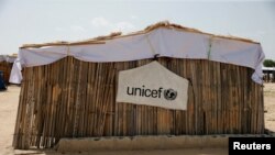 FILE - A banner with the UNICEF logo hangs on a makeshift school at an internally displaced persons camp on the outskirts of Maiduguri, northeast Nigeria, June 6, 2017. 