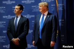 FILE - Then U.S. Republican presidential candidate Donald Trump welcomes his son Donald Trump Jr. to the stage at one of the New England Council's "Politics and Eggs' breakfasts in Manchester, New Hampshire, Nov. 11, 2015.