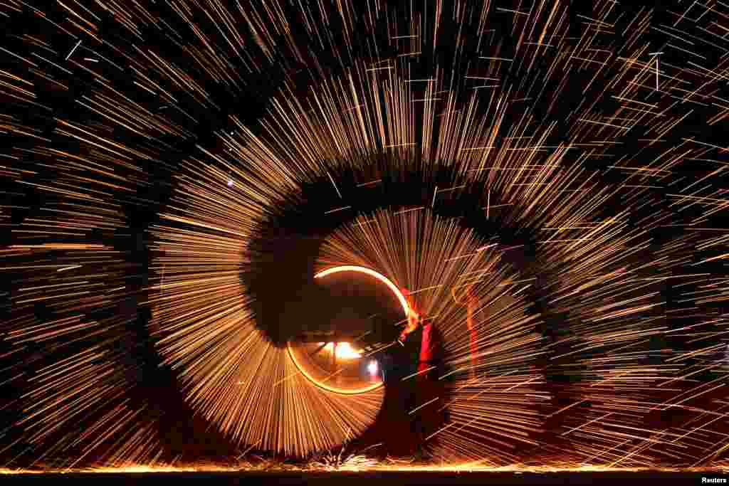 Folk artists throw molten iron to create sparks during an event to celebrate the Chinese Lunar New Year, in Shangqiu, Henan province, China, Feb. 11, 2019.