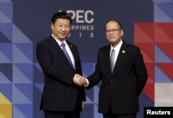 China's President Xi Jinping (L) is greeted by Filipino President Benigno Aquino III as he arrives for the Asia-Pacific Economic Cooperation (APEC) leaders meeting in Manila, Nov. 19, 2015.