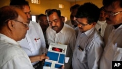 FILE - Indian election officials seal an electronic voting machine after the closing of a polling center in Kunwarpur village, Uttar Pradesh state, India.