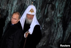 FILE - Russian President Vladimir Putin and Patriarch Kirill, the head of the Russian Orthodox Church, attend a ceremony in Moscow, Russia, Oct. 30, 2017.
