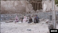 Earthquake victims sit near damaged houses in this undated handout photo taken in an undisclosed location in northwest Iran. Two powerful earthquakes killed 250 people and injured around 1,800 in northwest Iran, where rescue workers frantically combed the