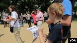 Grant Pennock, 9, consults a cheat sheet to identify some of the aircraft in the Arsenal of Democracy Flyover in Washington, D.C., May 8, 2015. He and his family are spending an academic year in Washington but otherwise live in Michigan.