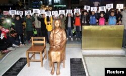 A statue of a girl representing World War II-era sexual victims of the Japanese military is seen during a rally in front of the Japanese consulate in Busan, South Korea, Dec. 31, 2016. Tokyo says the placement of yet another statue was a breach of a December 2015 deal struck between the two countries.