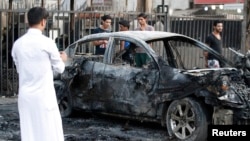 Warga melihat lokasi serangan bom mobil di Baghdad (18/9). (Reuters/Thaier Al-Sudani)