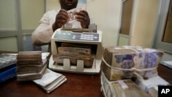Un homme en train de compter la monnaie nigériane, le naira, 20 octobre 2015.
