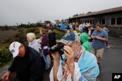 Visitors view Kilauea's summit crater outside the Jaggar Museum in Volcanoes National Park, Hawaii, May 10, 2018. The park is closing Friday because of the threat of an explosive volcanic eruption.