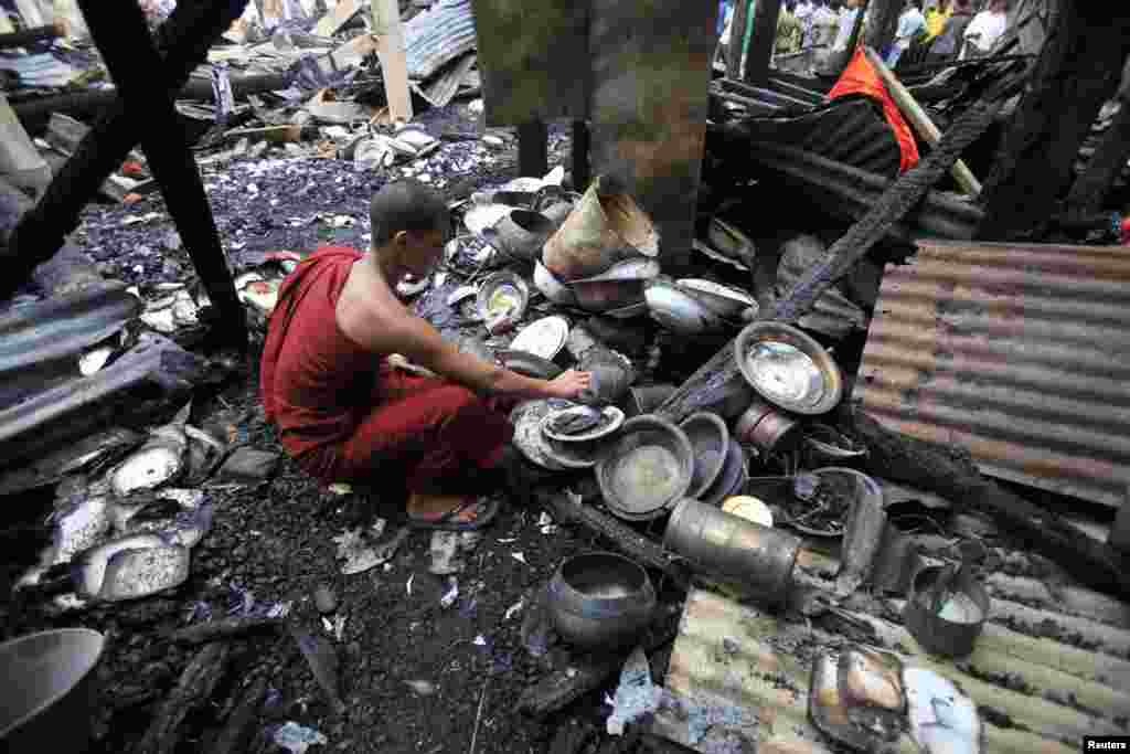 방글라데시 콕스 바자르의 불교 사원이 회교도들의 공격으로 불에 탄 가운데, 남은 물건을 수습하는 승려.