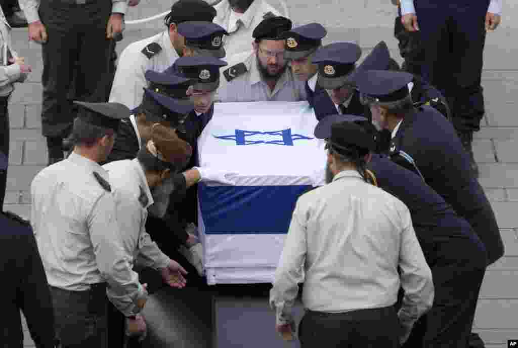 Petugas keamanan di Knesset membawa peti jenazah mantan perdana menteri Israel Ariel Sharon di Plaza Knesset, Yerusalem (12/1). (AP/Oded Balilty)