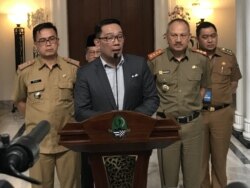 Gubernur Jawa Barat Ridwan Kamil (tengah) berbicara kepada wartawan usai memimpin rapat koordinasi penanganan corona se-Jabar di Gedung Sate, Selasa (3/3) siang. (VOA/Rio Tuasikal)