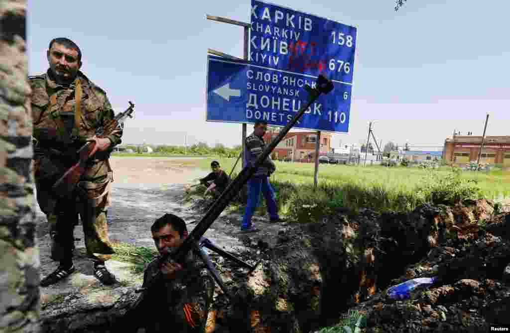 Pro-Russian rebels stand next to new trenches at a fortified front line rebel position near the town of Slovyansk, May 16, 2014.