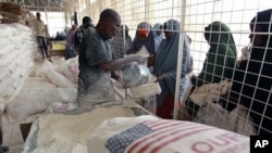 Newly arrived Somali refugee women receive relief food at a the World Food Program distribution center at the Ifo refugee camp in Dadaab, near the Kenya-Somalia border, August 1, 2011