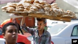 An Egyptian vendor carries bread downtown Cairo, Egypt, Aug. 5, 2013.