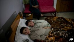 Abdul Rasheed, 9, front, and Shoaib Ahmed, 13, lie in a bed at a hospital in Islamabad, Pakistan, May 5, 2016. The boys are normal active children during the day, but lapse into a vegetative state — unable to move or talk - once the sun goes down.