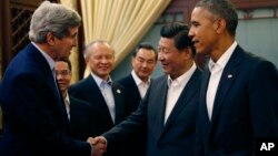 El secretario John Kerry estrecha la mano del presidente chino Xi Jinping, mientras observa el presidente Obama.