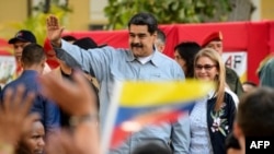 Le président vénézuélien Nicolas Maduro (à gauche) prononce un discours devant son épouse, Cilia Flores, sur la campagne de signatures qu'il a lancée pour exhorter les États-Unis à mettre fin aux menaces d'intervention contre son gouvernement, sur la place Bolivar à Caracas, le 7