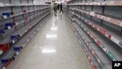 People shop for food from almost empty shelves at a big-box supermarket in Tokyo. Supermarket shelves are running empty despite authorities assuring citizens there is no need to panic from the crisis unfolding at a quake-stricken nuclear power plant, Marc
