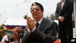 FILE - In this March 26, 2015, file photo, Cambodian Deputy Prime Minister Sok An, center, prays at the Tuol Sleng Genocide Museum memorial in Phnom Penh, Cambodia. A government statement said Wednesday, March 15, 2017, that Sok An, who was one of Prime Minister Hun Sen's closest political and personal allies, has died at age 66. (AP Photo/Heng Sinith, File)