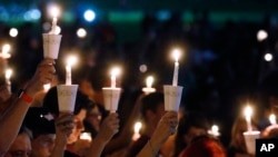 Attendees raise their candles at a candlelight vigil for the victims of the shooting at Marjory Stoneman Douglas High School, in Parkland, Fla., Feb. 15, 2018. 