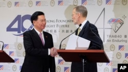 Taiwan Foreign Minister Joseph Wu, left, and American Institute in Taiwan (AIT) director William Brent Christensen shakes hands during a press conference in Taipei, Taiwan, March 19, 2019. 