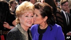 FILE - Debbie Reynolds (left) and Carrie Fisher arrive at the Primetime Creative Arts Emmy Awards in Los Angeles, Sept. 10, 2011.