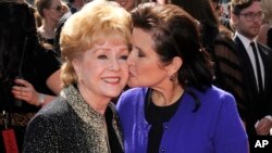 FILE - Debbie Reynolds (left) and Carrie Fisher arrive at the Primetime Creative Arts Emmy Awards in Los Angeles, Sept. 10, 2011.