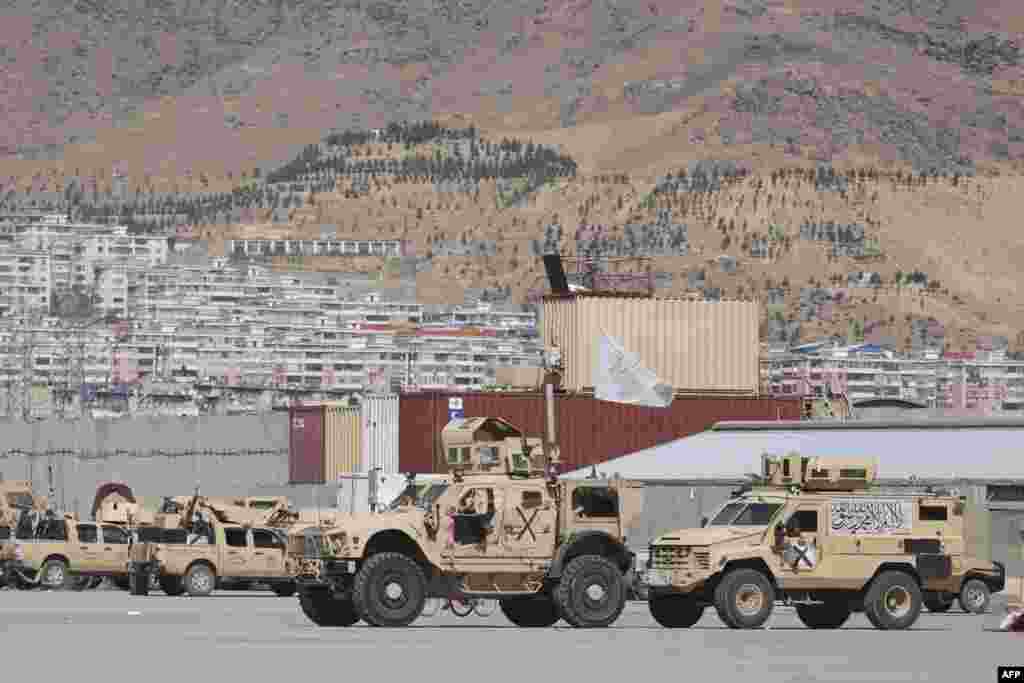 Armored vehicles flying Taliban flags are parked at a deserted U.S. military camp at the airport in Kabul, Afghanistan, Sept. 14, 2021.